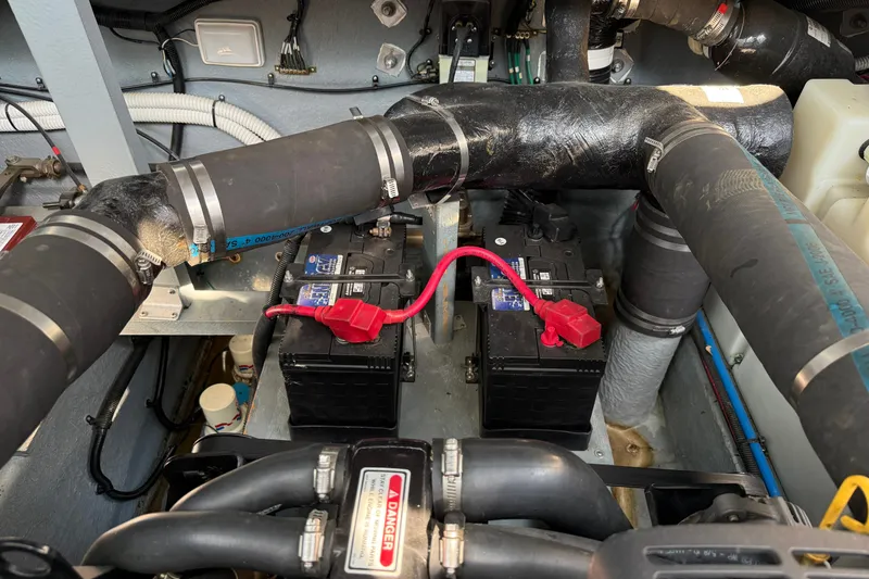 Slide: The Image of Engine compartment of a 2000 Sea Ray 340 Sundancer with visible batteries and hoses. - 25