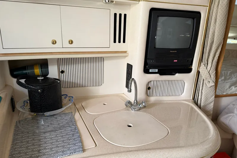 Slide: The Image of Interior of 2000 Sea Ray 340 Sundancer with sink, TV, and storage cabinets. - 21