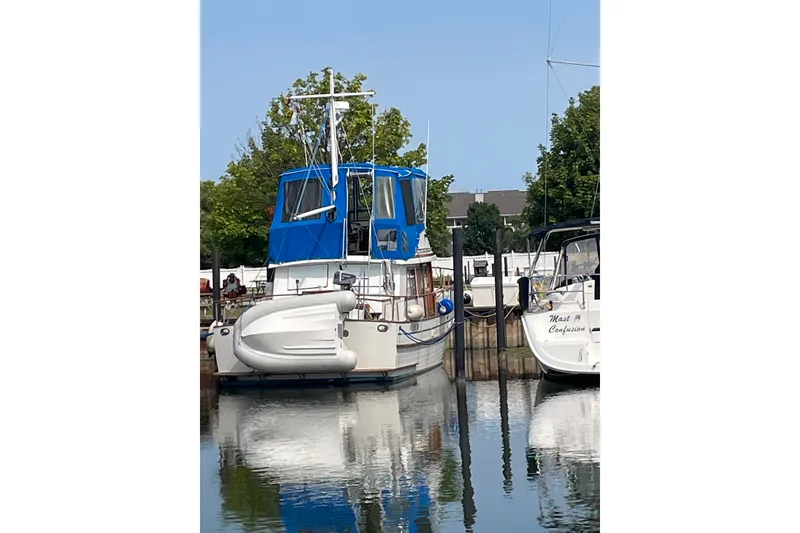 Slide: The Image of 1982 Albin 36 Trawler with blue canopy docked at marina. - 3