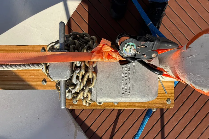 Slide: The Image of Anchor chain and cleat on 1982 Albin 36 Trawler deck, secured with orange strap. - 12