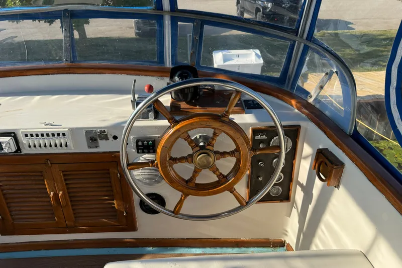 Slide: The Image of Wooden helm of a 1982 Albin 36 Trawler with classic nautical controls. - 16