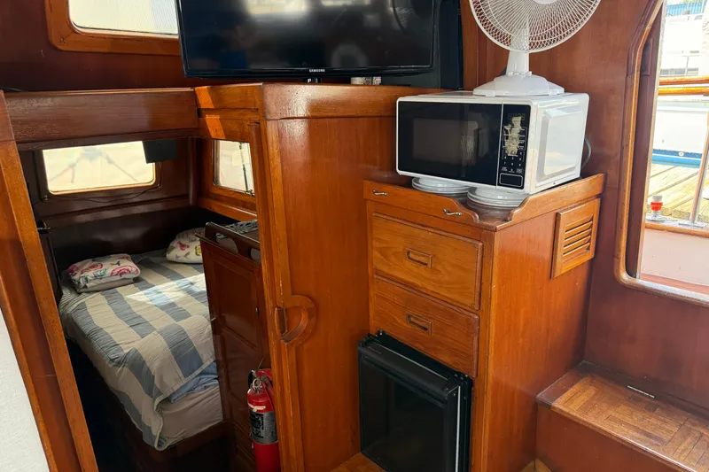 Slide: The Image of Interior of 1982 Albin 36 Trawler with bed, microwave, and wooden cabinetry. - 27