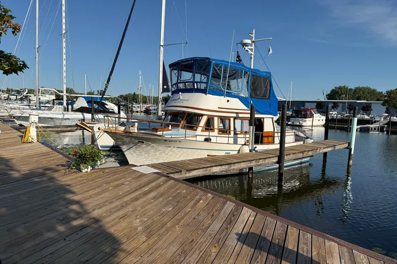 Slide: The Image of 1982 Albin 36 Trawler docked at marina, clear blue sky, wooden pier. - 2