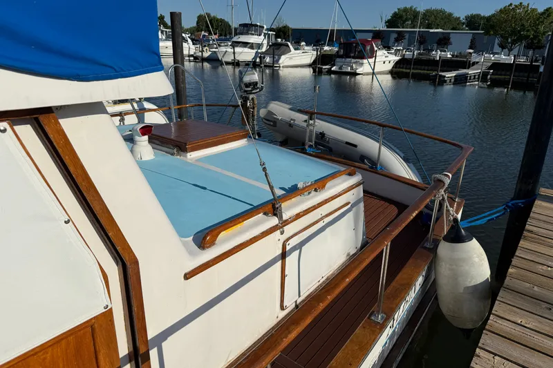 Slide: The Image of 1982 Albin 36 Trawler docked at marina, featuring wooden accents and blue cover. - 7