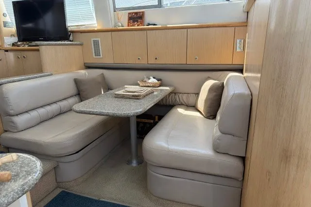 Slide: The Image of Interior of 1997 Maxum 4100 SCA yacht with cozy dining area and beige seating. - 21