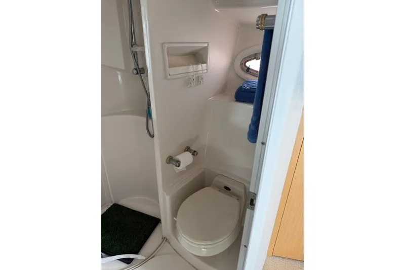 Slide: The Image of 1997 Maxum 4100 SCA yacht bathroom with shower, toilet, and porthole window. - 24