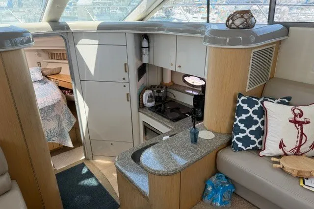 Slide: The Image of Interior of a 1997 Maxum 4100 SCA yacht with kitchen and cozy seating area. - 22