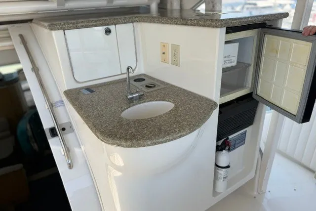 Slide: The Image of 1997 Maxum 4100 SCA yacht kitchenette with sink, mini-fridge, and countertop. - 14