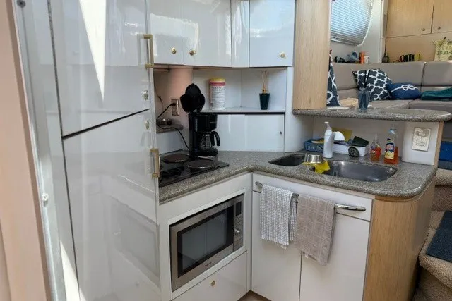 Slide: The Image of Kitchen area of a 1997 Maxum 4100 SCA yacht with modern appliances and sleek design. - 23