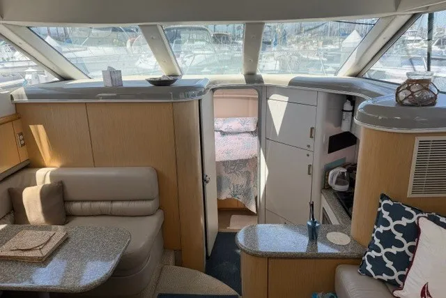 Slide: The Image of Interior of 1997 Maxum 4100 SCA yacht, featuring cozy seating and modern amenities. - 19