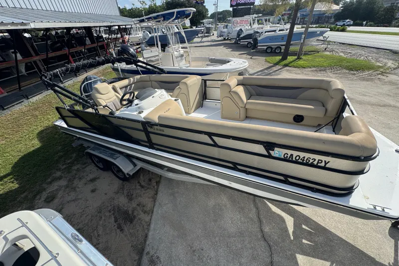 The Image of 2016 Hurricane FunDeck 226 boat on trailer, beige seating, parked outdoors. - 0