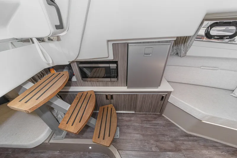 Slide: The Image of Interior of the Sea Ray 320 Sundancer DA Coupe with wooden steps, microwave, and refrigerator. - 26