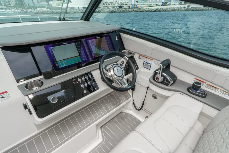 Slide: The Image of The cockpit of the 2025 Sea Ray 320 Sundancer DA Coupe features modern navigation systems and luxurious seating. - 13