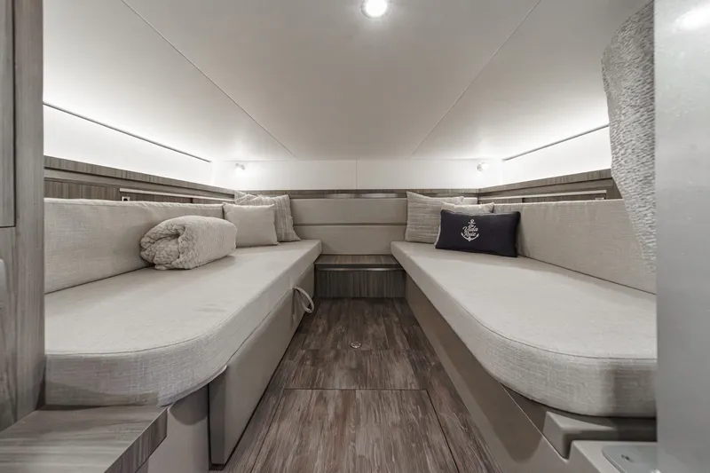 Slide: The Image of Interior of a 2025 Sea Ray 320 Sundancer DA Coupe with two cushioned benches and pillows. - 27