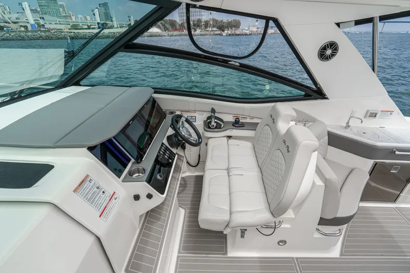 Slide: The Image of The cockpit of the 2025 Sea Ray 320 Sundancer DA Coupe features modern instruments and luxurious seating. - 12
