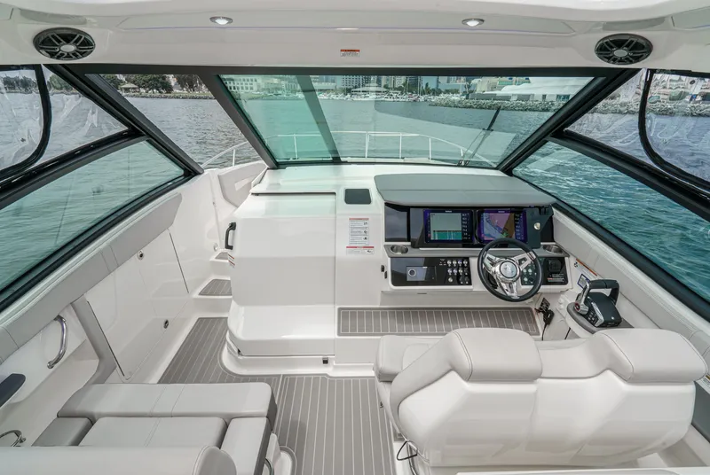 Slide: The Image of The cockpit of the 2025 Sea Ray 320 Sundancer DA Coupe features modern instruments and comfortable seating. - 10
