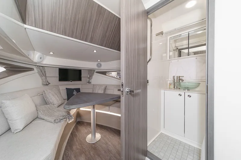 Slide: The Image of Interior of the 2025 Sea Ray 320 Sundancer DA Coupe with elegant seating area and modern bathroom. - 29