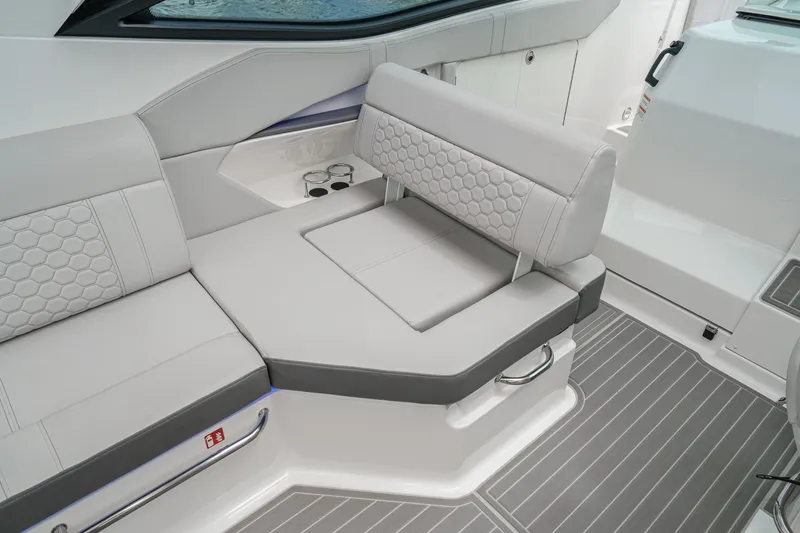 Slide: The Image of The 2025 Sea Ray 320 Sundancer DA Coupe features sleek, gray upholstery with a honeycomb pattern. - 8