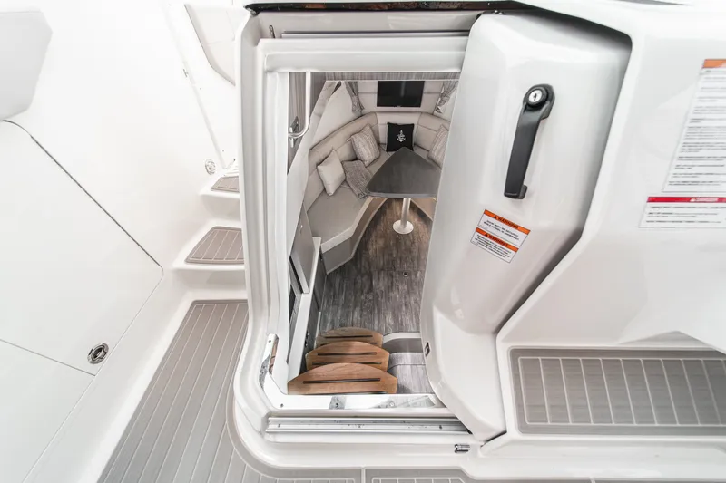 Slide: The Image of View into the cabin of a Sea Ray 320 Sundancer DA Coupe with gray flooring and seating area. - 19