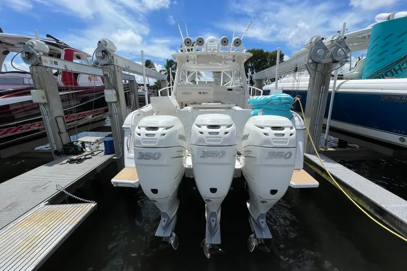 Slide: The Image of 2010 Intrepid 390 Sport Yacht with triple Mercury 350 engines docked under a clear sky. - 40