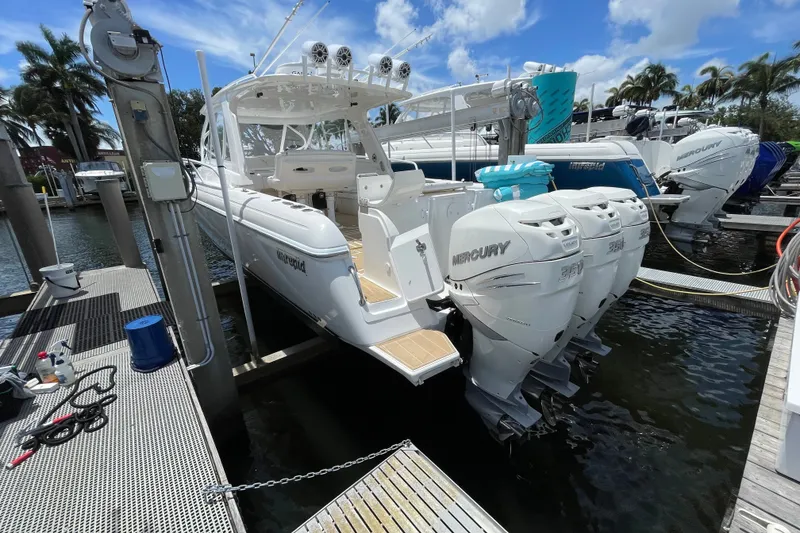 Slide: The Image of 2010 Intrepid 390 Sport Yacht docked with triple Mercury engines, under a clear blue sky. - 41
