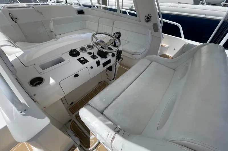 Slide: The Image of 2010 Intrepid 390 Sport Yacht cockpit with white leather seating and modern controls. - 26