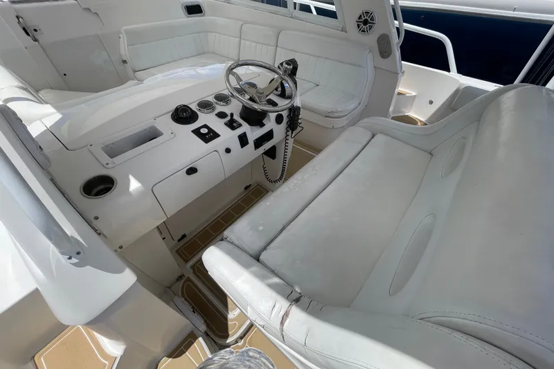 Slide: The Image of Interior of a 2010 Intrepid 390 Sport Yacht with white seating and control panel. - 25