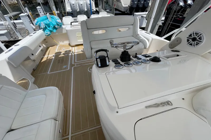 Slide: The Image of Cockpit of a 2010 Intrepid 390 Sport Yacht with white seating and control panel. - 30