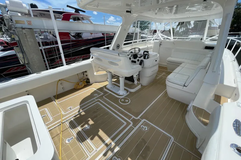 Slide: The Image of 2010 Intrepid 390 Sport Yacht interior with helm, seating, and teak-style flooring. - 23