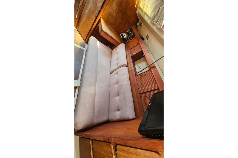 Slide: The Image of Interior of a 1989 Hunter 30 sailboat with cushioned seating and wooden cabinetry. - 15