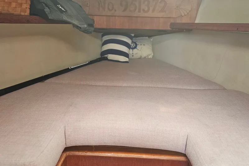 Slide: The Image of Interior cabin of a 1989 Hunter 30 sailboat with cushioned berth and nautical decor. - 10