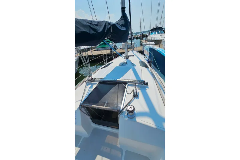 Slide: The Image of 1989 Hunter 30 sailboat deck view at marina, showcasing rigging and hatch. - 26