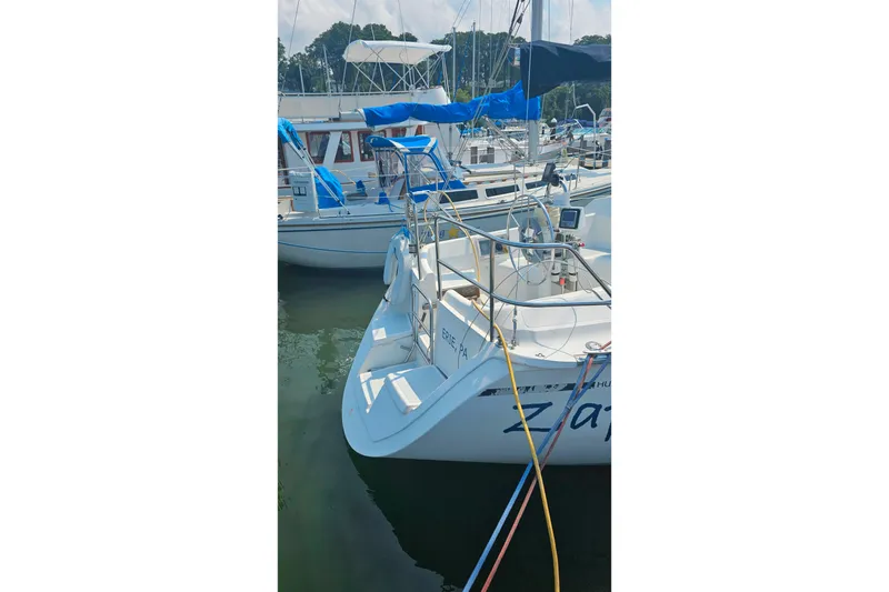 Slide: The Image of 1989 Hunter 30 sailboat docked in marina, featuring blue accents and clean design. - 6