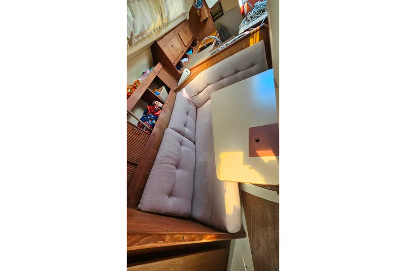 Slide: The Image of Interior of a 1989 Hunter 30 sailboat with cushioned seating and a small table. - 12