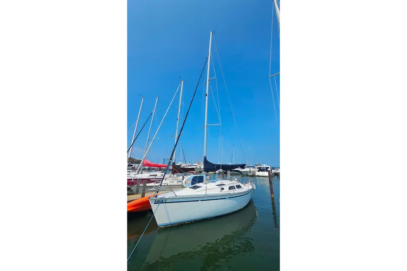 Slide: The Image of 1989 Hunter 30 sailboat docked in a marina under a clear blue sky. - 3