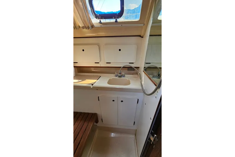 Slide: The Image of 1989 Hunter 30 yacht interior with sink, cabinets, and window. - 22