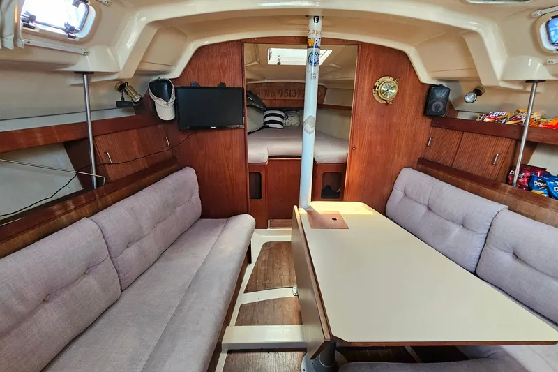 Slide: The Image of Interior of a 1989 Hunter 30 sailboat with cozy seating and wooden accents. - 11