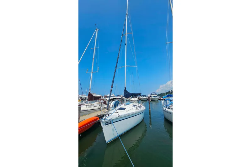 Slide: The Image of 1989 Hunter 30 sailboat docked in a marina under a clear blue sky. - 2