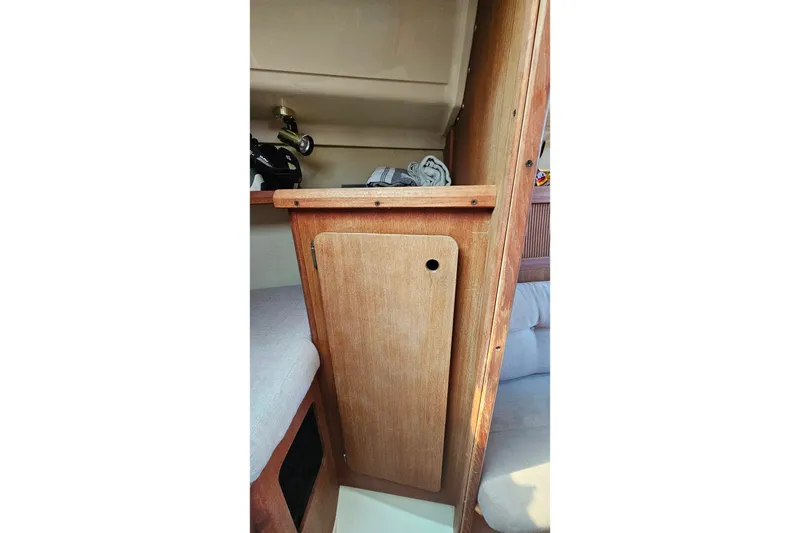 Slide: The Image of Interior of a 1989 Hunter 30 sailboat featuring wooden cabinetry and seating area. - 16