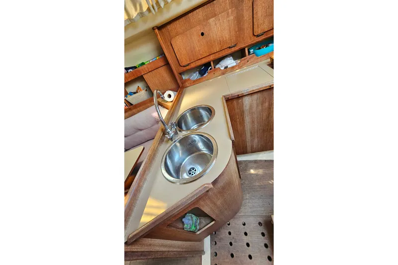 Slide: The Image of Interior of 1989 Hunter 30 sailboat featuring a compact kitchen with dual sinks. - 19