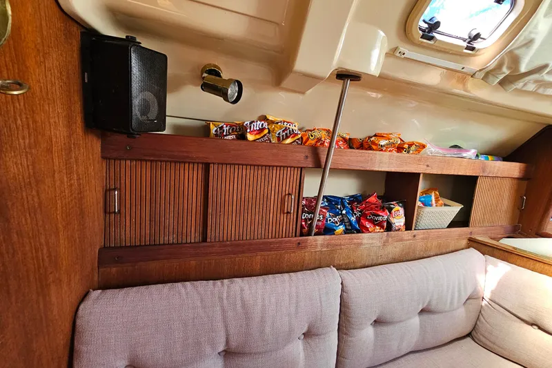 Slide: The Image of Interior of a 1989 Hunter 30 sailboat with snacks on wooden shelves. - 18