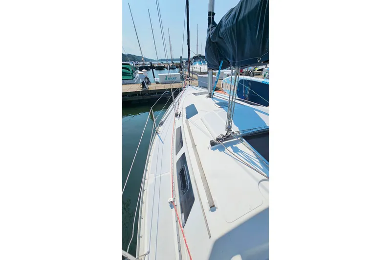 Slide: The Image of 1989 Hunter 30 sailboat docked at marina, showcasing deck and rigging. - 27