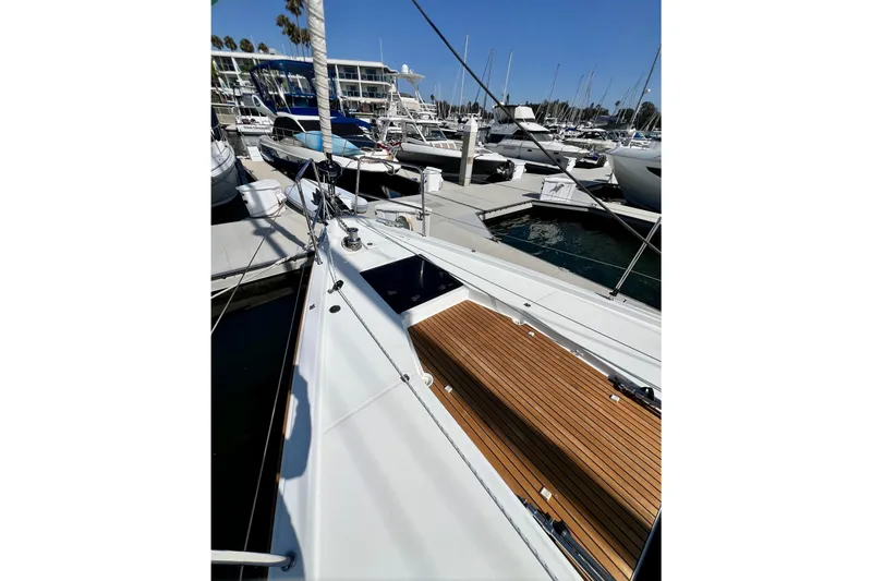 Slide: The Image of 2018 Jeanneau 54 yacht docked at marina, showcasing sleek deck design and modern features. - 18