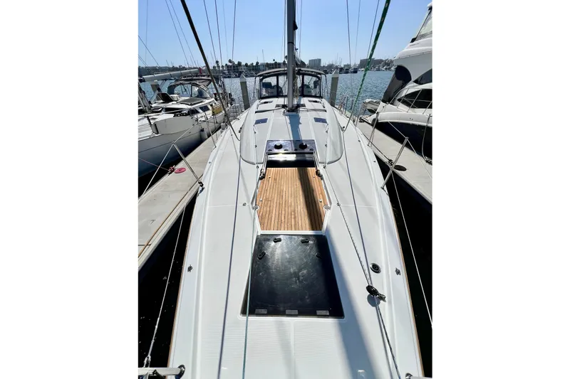 Slide: The Image of 2018 Jeanneau 54 sailboat docked, showcasing sleek deck design and marina backdrop. - 20