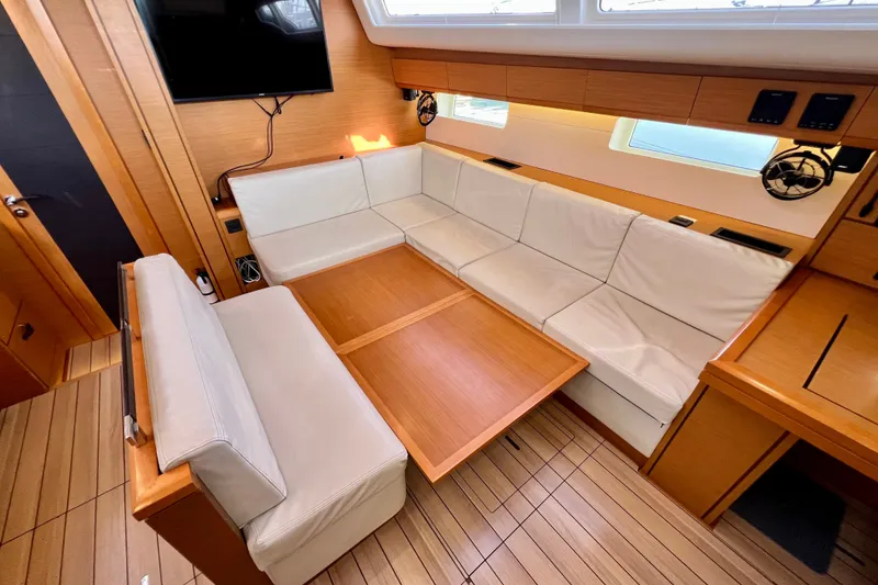 Slide: The Image of Luxurious interior of 2018 Jeanneau 54 yacht with elegant seating and wooden table. - 49