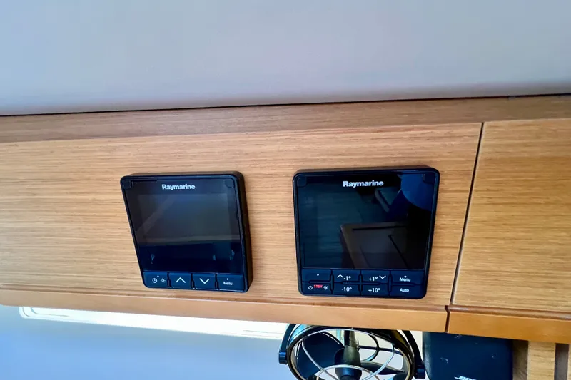 Slide: The Image of Raymarine control panels on 2018 Jeanneau 54 yacht, featuring sleek wooden interior design. - 57