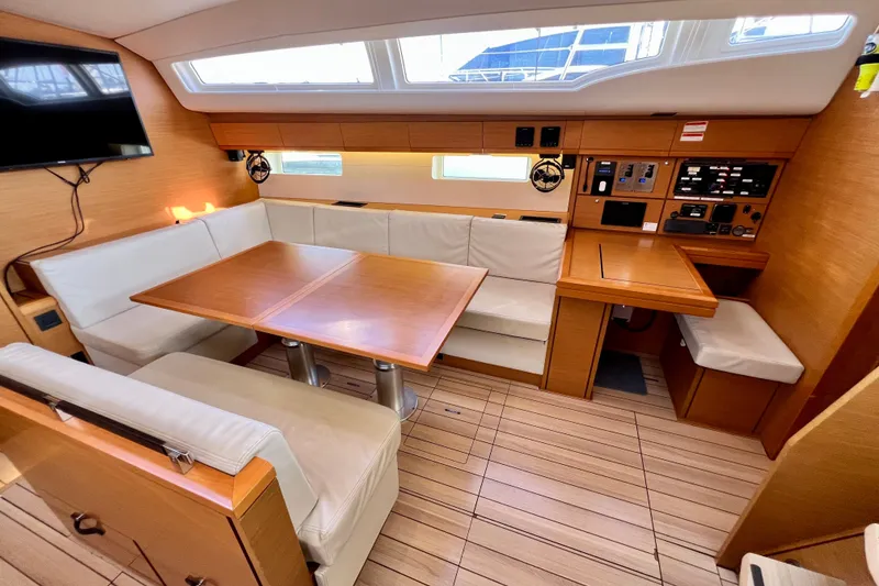 Slide: The Image of Interior of 2018 Jeanneau 54 yacht with dining area and navigation station. - 54