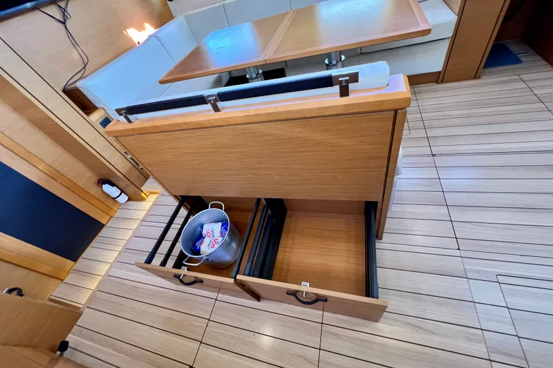 Slide: The Image of Interior of 2018 Jeanneau 54 yacht with open wooden drawers and seating area. - 55