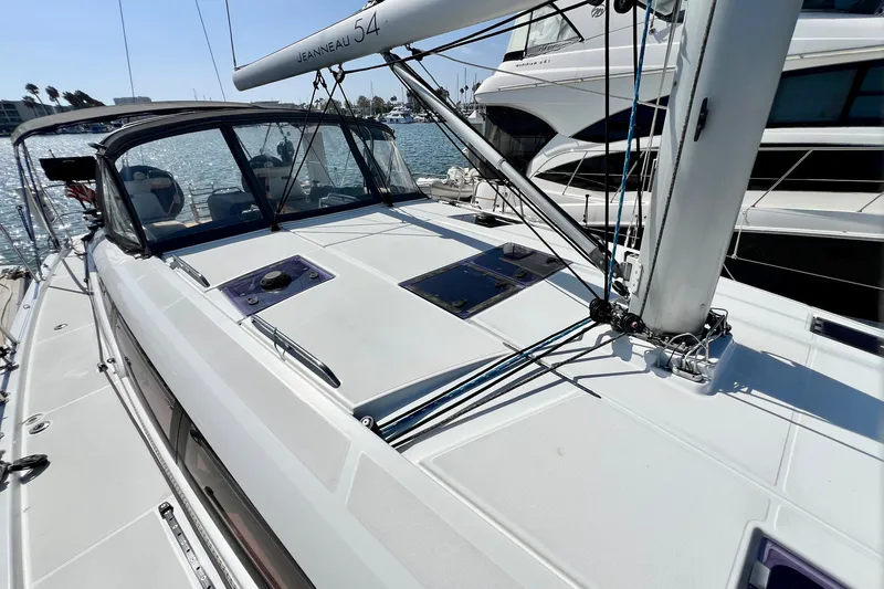 Slide: The Image of 2018 Jeanneau 54 sailboat deck with sleek design, docked in a marina. - 23