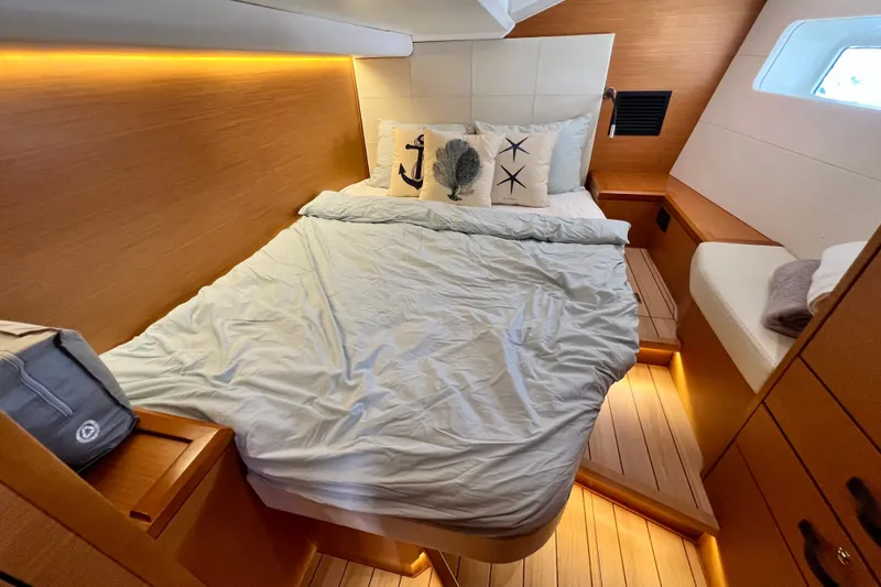 Slide: The Image of Luxurious cabin interior of 2018 Jeanneau 54 yacht with cozy bedding and ambient lighting. - 92